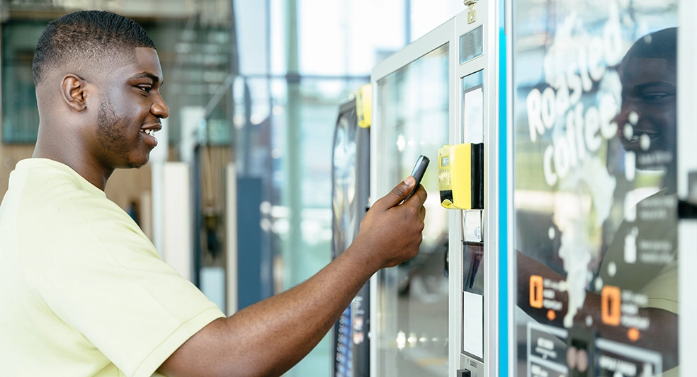 Young male customer interacting with a vending machine